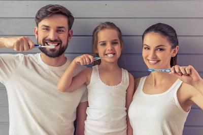 Parents and child brushing their teeth