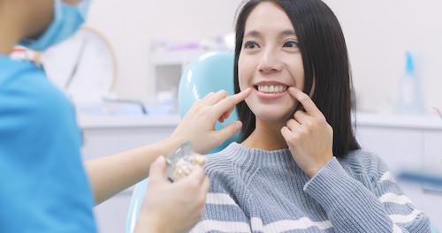 Woman pointing to her tooth at emergency dentist in Tampa, FL