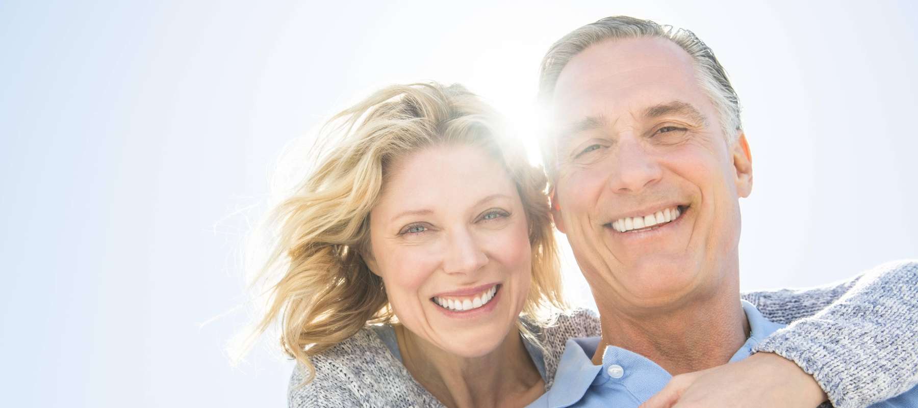 Couple in North Tampa confidently smiling with their implant dentures