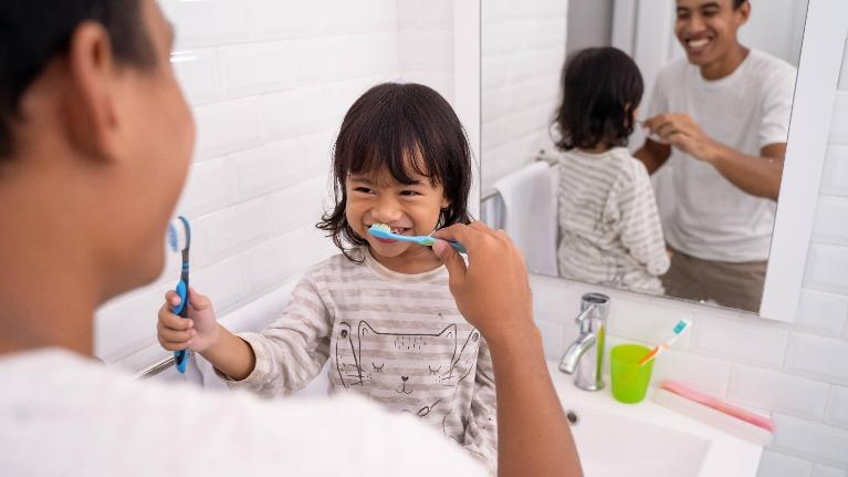 father and child brushing each others teeth