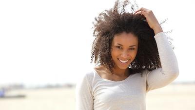 woman smiling holding her hair