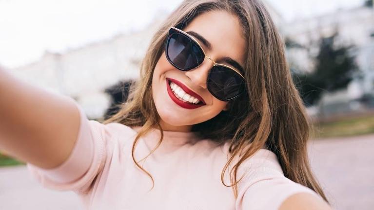 woman smiling with sunglasses and red lips