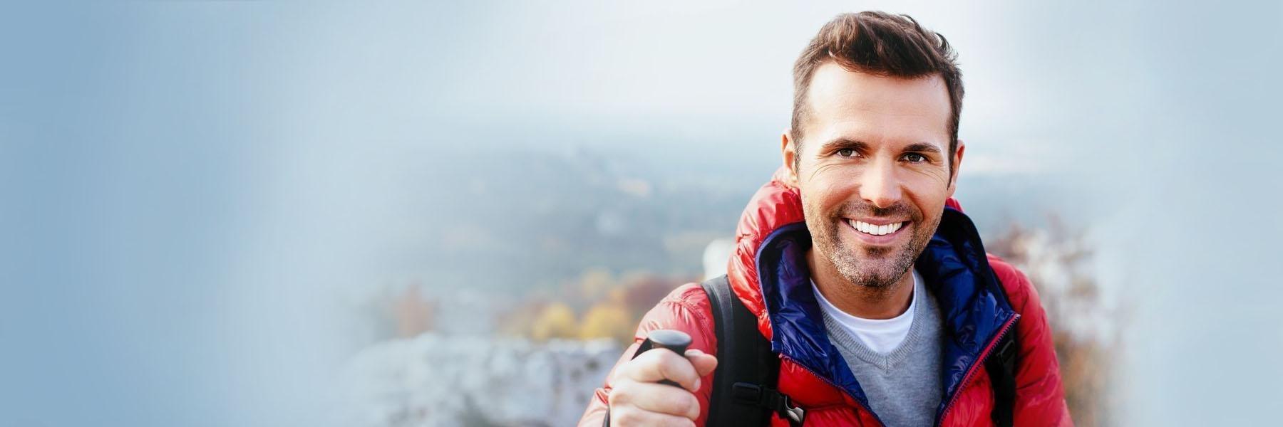 Man in red jacket showing off his new dental implants